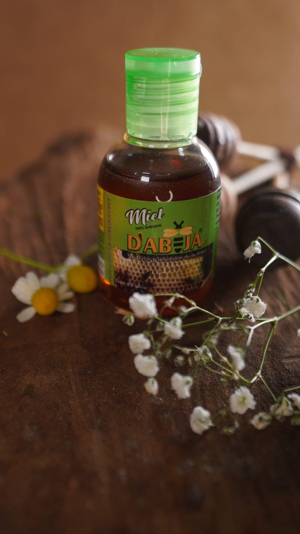 Frasco de miel Dabejaz con flores sobre madera